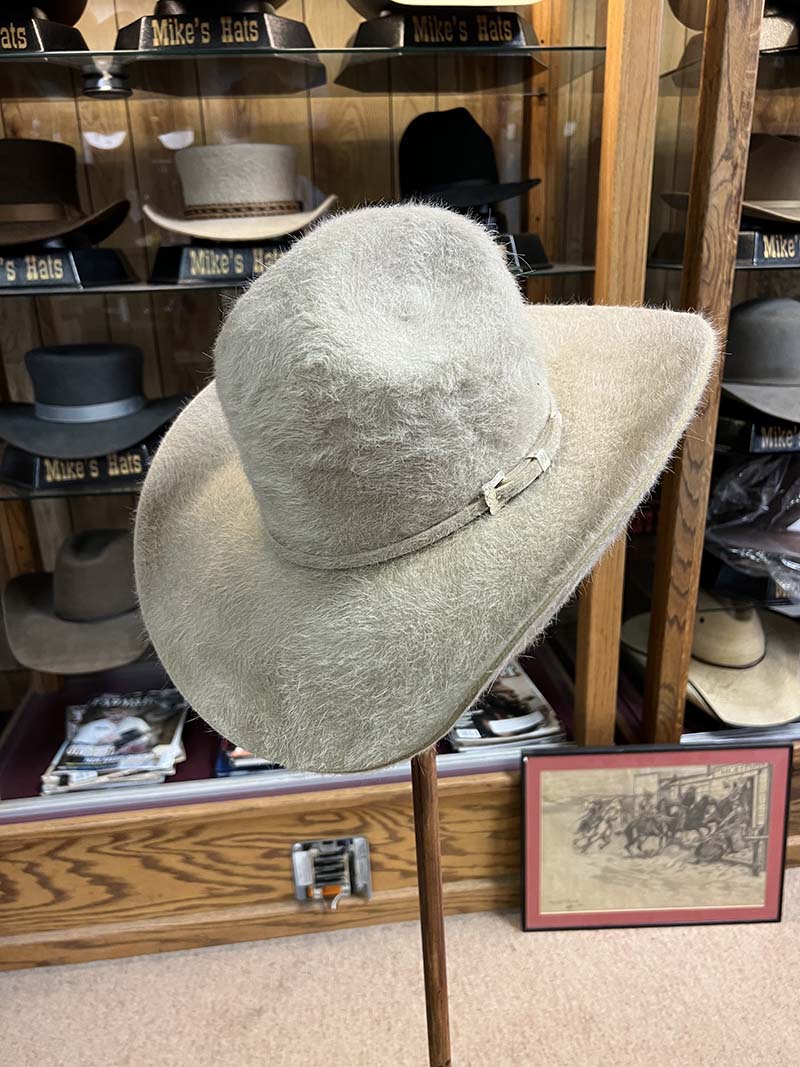 A light-colored textured cowboy hat on display inside Mike’s Custom Hatters