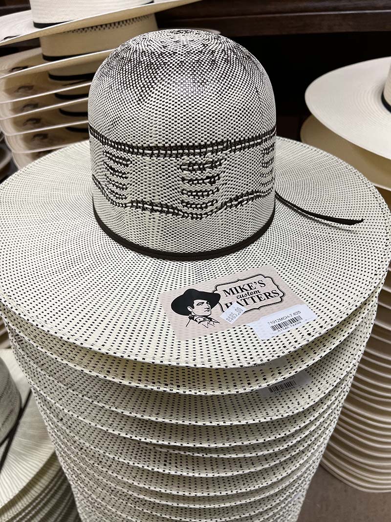 Patterned straw western hats with Mike’s Custom Hatters labels in the shop