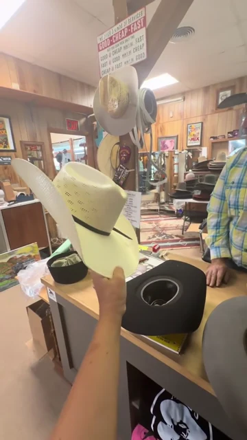 Video of the hat shop and a light-colored western hat with a dark band displayed inside and outdoors