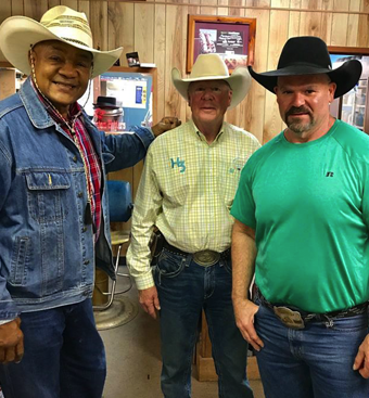 George Foreman photographed with two other people inside Mike’s Custom Hatters