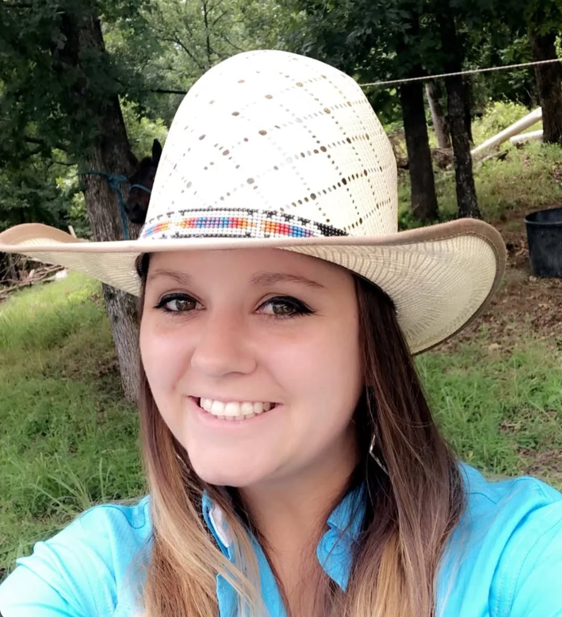 A woman outdoors wearing a ventilated light woven western hat with a colorful patterned band